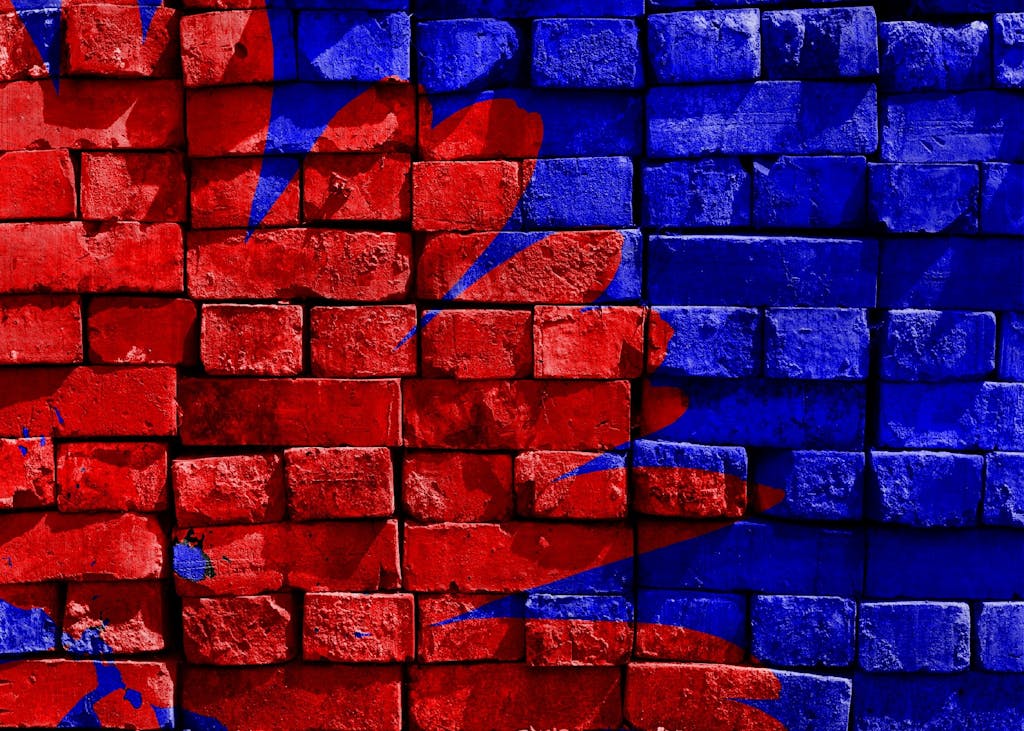 Vibrant red and blue graffiti art on a textured brick wall, creating a striking visual impact.
